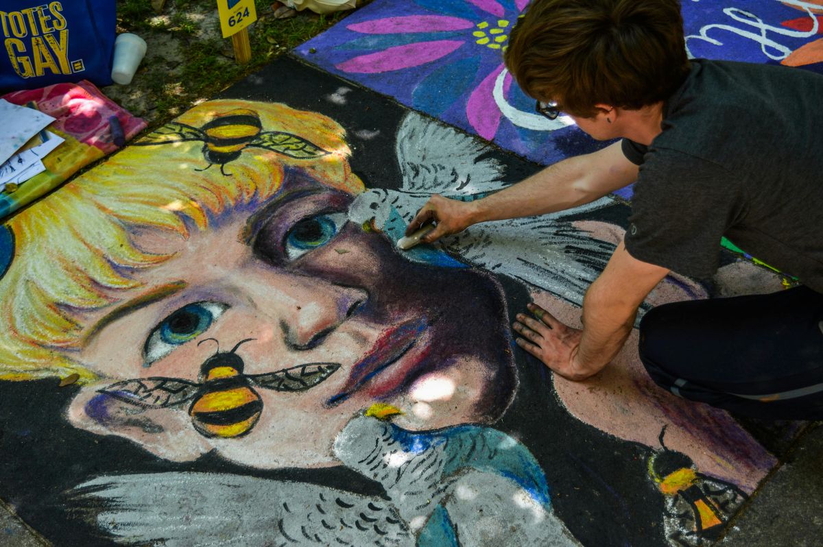 man painting a pavement with a girl birds, and bees